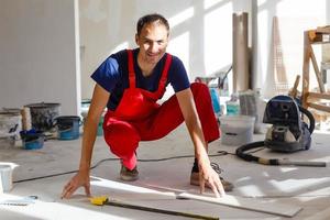 Tiler installing ceramic tiles on a floor photo