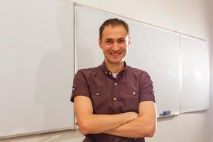 Male teacher listening to students at adult education class photo