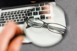 Gafas invertidas con montura negra en el teclado de la computadora con una profundidad de campo muy baja. foto