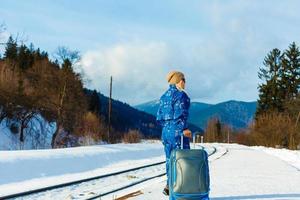 mujer en trajes de esquí se encuentra cerca del ferrocarril foto