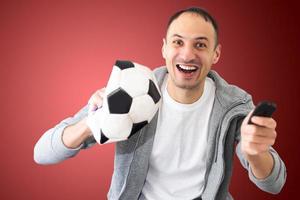 male football fan with a crumpled ball and remote control photo