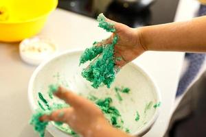 Little cute girl is cooking on kitchen. Having fun while making cakes and cookies photo