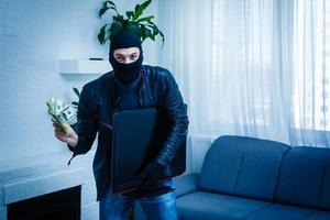 Man burglar stealing tv set from house photo