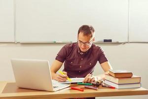 Portrait of confident Caucasian male teacher in classroom photo