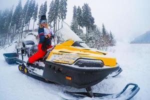 retrato de mujer en motonieve.concepto de deporte de nieve y estilo de vida saludable foto