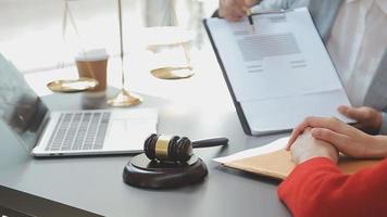 Business and lawyers discussing contract papers with brass scale on desk in office. Law, legal services, advice, justice and law concept picture with film grain effect video