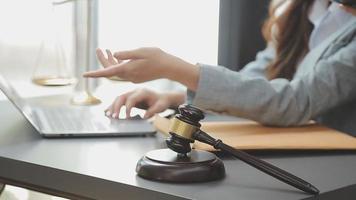 Business and lawyers discussing contract papers with brass scale on desk in office. Law, legal services, advice, justice and law concept picture with film grain effect video