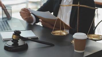 Business and lawyers discussing contract papers with brass scale on desk in office. Law, legal services, advice, justice and law concept picture with film grain effect video