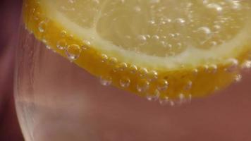 Soda bubbles on a slice of lemon in a glass video