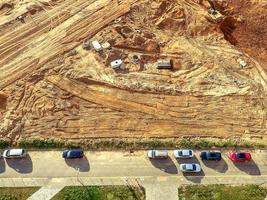 campo de construcción hecho de arena y barro. un lugar para construir una base, un campo con rastros de grandes equipos de construcción. aparcamiento cercano foto