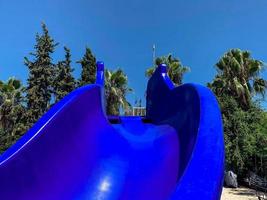 tobogán de agua de plástico azul para deportes acuáticos y diversión en el divertido parque acuático para niños y adultos en el complejo tropical del hotel foto