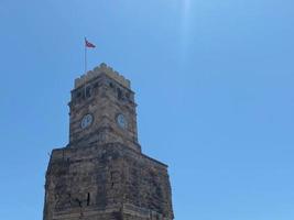 antigua torre del reloj con cielo azul y nubes en adana, turquía. histórica torre del reloj antiguo foto