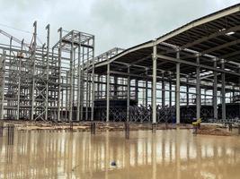 construction of a new complex at the plant. metal structures for the construction of the foundation. building material is covered with rust and lies in a puddle of water photo