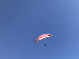 Skydiver and colorful parachute on blue sky background photo