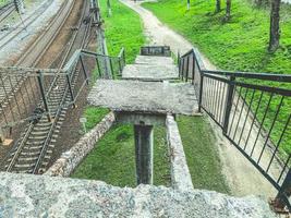 antiguo puente ferroviario de hormigón con escalones rotos. escalera oxidada y rota con escalones caídos. mala infraestructura foto