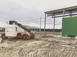 sitio de construcción de un complejo industrial. máquina para el transporte de materiales de construcción pesados en naranja. suciedad en el suelo, rastros de maquinaria pesada foto