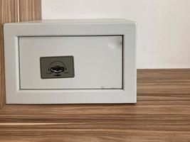 White iron small safe in the hotel room for storing valuables and money photo