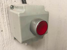 botón de alarma rojo en una caja gris. la alarma se conecta con un cable negro para llamar al guardia. seguridad contra incendios. protección contra los delincuentes foto