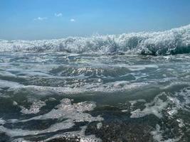 Waves, splashes of water on the beach at the sea on vacation in a tourist warm eastern tropical country southern paradise resort on vacation. The background photo