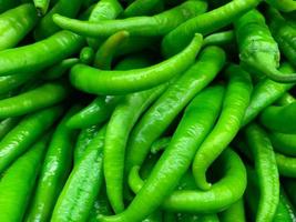 Fresh green peppers from the produce market as a textured food background photo