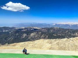 paratroopers on the observation deck put on equipment. they are wearing large briefcases with a parachute. skydivers take a selfie at the foot of the mountain, active recreation photo