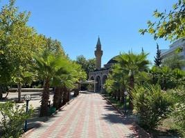 View of a beautiful ancient mosque in the Arabian style, a temple for prayers of Muslims in a tropical warm country with palm trees photo