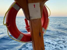 aro salvavidas en el amarre y el barco en un fondo foto