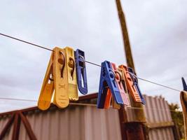 Colorful clothespins on the thread for linen, outside the window. photo