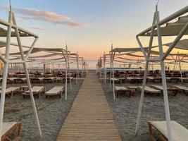 Sun loungers and sunshade with umbrellas on the beach on the sea on vacation in a tourist warm eastern tropical country southern resort photo