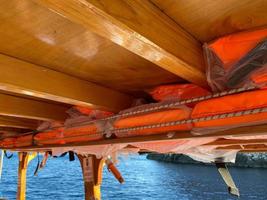 Boat lifesaving equipment life jackets,lots of bright orange color. It is hung under the roof of a passenger ship, intended for passengers to use in the event of a collapse or falling into water photo