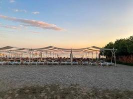 Sun loungers and sunshade with umbrellas on the beach on the sea on vacation in a tourist warm eastern tropical country southern resort photo