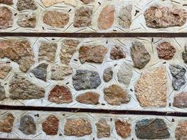 Background, texture, stone wall of round stones cobblestones bricks natural surface natural sharp convex rough stone cobblestone with cracks photo