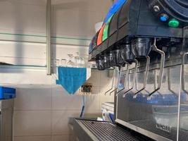 Soft drink dispenser machine with many taps of soda lemonade in a cafe fast food restaurant photo