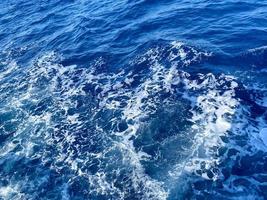 Aerial view to ocean waves. Blue water background photo