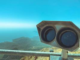 una plataforma de observación con binoculares con grandes lentes negros sobre el fondo de un cielo azul soleado. lupa de ambiente. prismáticos panorámicos para turistas foto