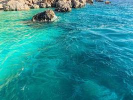 agua azul con espuma burbujeante, costa marina para que los turistas se relajen en el resort. descansar en un país cálido con mar y montaña. olas turquesas del mar foto