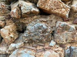 Background, texture, stone wall of round stones cobblestones bricks natural surface natural sharp convex rough stone cobblestone with cracks photo