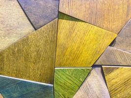 textura brillante, fondo. Los triángulos de madera están pintados en diferentes colores. panel en la pared. elementos decorativos en el interior