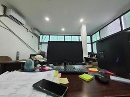 Jakarta, Indonesia in July 2022. An office desk in a project site office, there is a computer monitor along with its keyboard photo