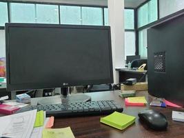 Jakarta, Indonesia in July 2022. An office desk in a project site office, there is a computer monitor along with its keyboard photo