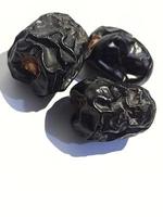 Isolated photo of three ajwa dates. Ajwa dates or also known as Prophetic Dates.