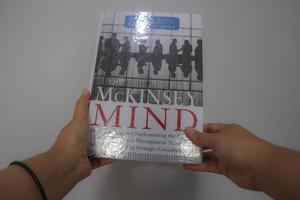 West Java, Indonesia on October 2022. A hand is holding a best selling book entitled Mc Kinsey Mind by Ethan M Rasiel photo