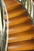 Wooden stairs with wooden railing in a building. photo