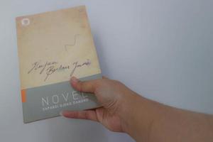 West Java, Indonesia on July 2022. A hand is holding a novel which is very popular and best seller and phenomenal in Indonesia. photo