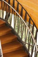 Wooden stairs with wooden railing in a building. photo