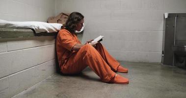 gefangener, gutaussehender mann in der gefängniszelle, der bibel liest, eingesperrt, gefängnis video