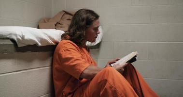 prisioneiro, homem bonito na cela lendo a bíblia, encarcerado, cadeia video