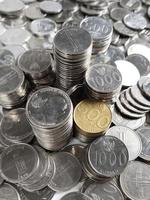 Collection of Indonesian's Rupiah coins with 100, 200, 500 - gold, 500 - silver, 1000. Piled and scattered coins in one frame. Showing front and back side of coins photo