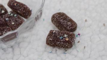 Caramelos de gelatina con recubrimiento de azúcar en recipiente de vidrio foto