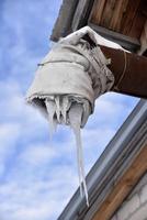 Spontaneous ventilation pipe in a house with icicles and ice in winter. The ventilation pipe is insulated in winter weather. photo